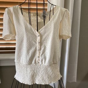 Cream colored size small feminine top with button detail. NWT